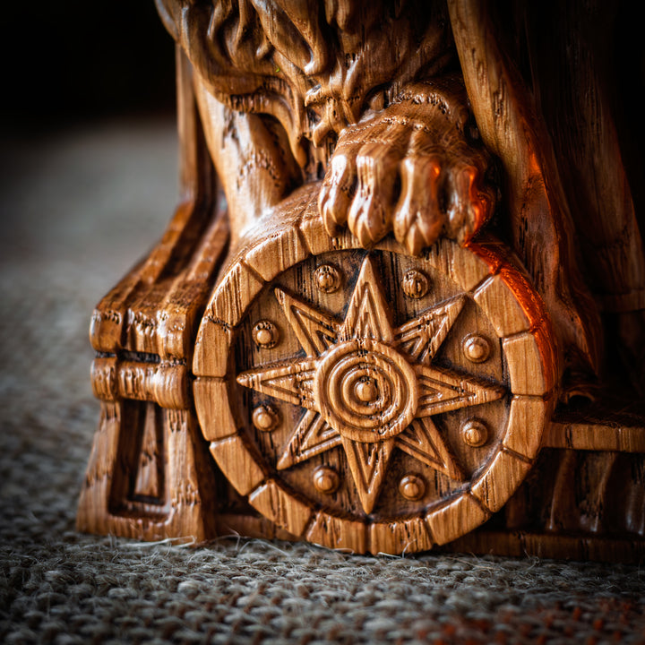 Close-up of Ishtar statue’s lion paw resting on a carved Mesopotamian star-wheel.