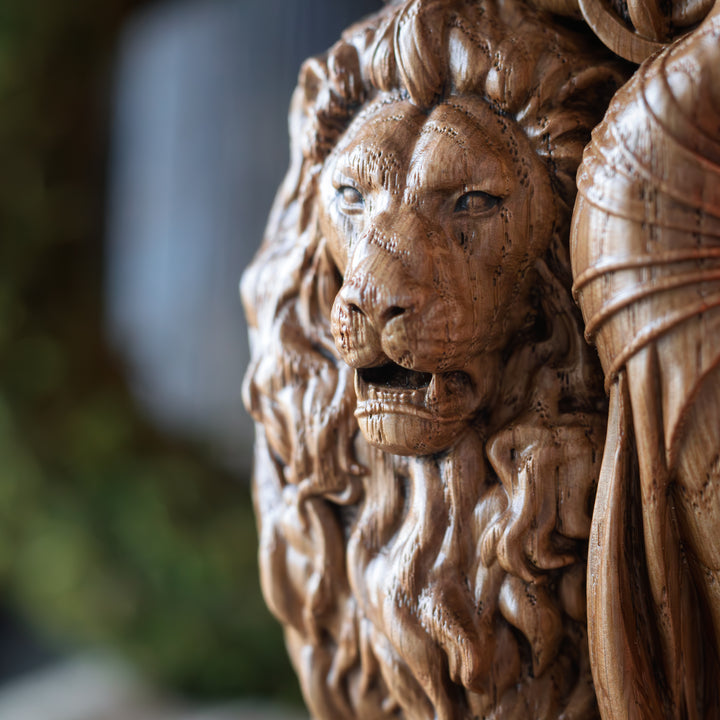 Close-up of the intricately carved lion's face on the wooden Ishtar statue, showcasing fine fur details.